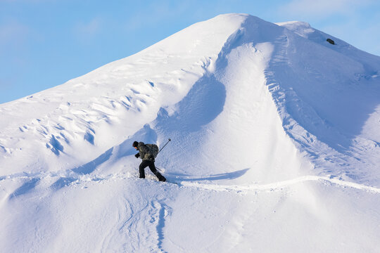 A snowshoer follows a trail across Canwell Glacier in the winter; Alaska, United States of America