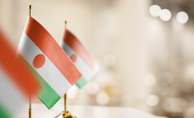 Small flags of the Niger on an abstract blurry background