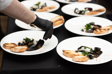 chief serving mussels in white wine sauce and white bread toasts
