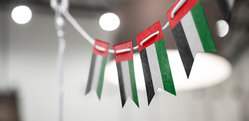 A garland of United Arab Emirates national flags on an abstract blurred background