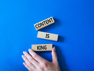 Content is king symbol. Concept words Content is king on wooden blocks. Businessman hand. Beautiful blue background. Business and Content is king concept. Copy space.