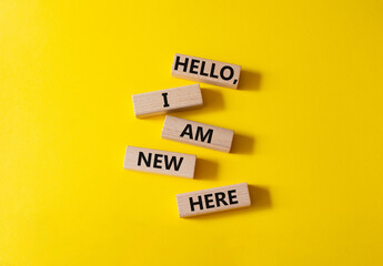 Hello I am new here symbol. Concept words Hello I am new here on wooden blocks. Beautiful yellow...