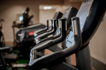 A row of exercise machines in a gym