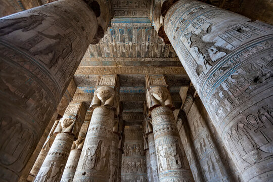 Stone columns and ceiling displaying hieroglyphic carvings at the Hathor Temple, Dendera, Egypt