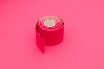 Red kinesio tape on a pink background. Elastic tape for kinesiology taping