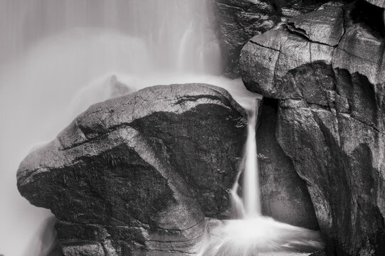 Black and white image of a cascading waterfall over rocks in Mount Baker National Recreation Area; Washington, United States of America