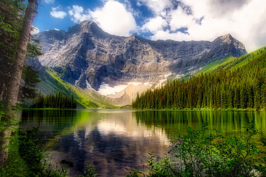 Rawson Lake with a mirror image of forest and mountains in the water, Kananaskis Provincial Park; Alberta, Canada