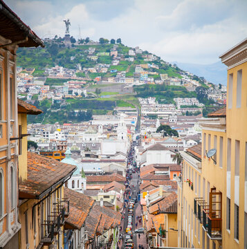 Looking down Quito street toward Virgin de El Panecillo, the world's tallest aluminum statue of the winged Virgin Mary on the hilltop of El Panecillo; Quito, Ecuador