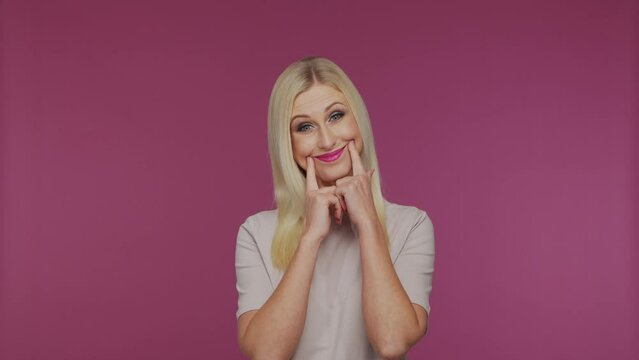Young beautiful blond girl in the studio. Portrait of emotional girl on blue background.