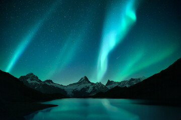Aurora borealis. Northern lights in winter mountains. Sky with polar lights and stars. Stars reflection in lake water