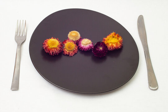 Dried Flowers On A Black Ceramic Plate, Side View