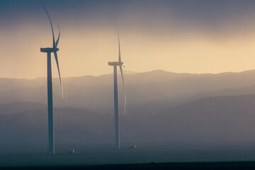 Obraz premium Wind generation towers in the sunlight during sunrise