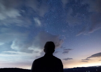 Silhouette of a man looking up at a star filled sky along Skyline Drive in Shenandoah National Park in Virginia.
