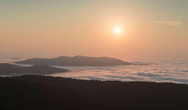 The sunrise burns off early morning fog in the Blue Ridge Mountains, Shenandoah National Park, Virginia.