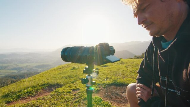 Photographer takes pictures of nature at sunrise with big telephoto lens