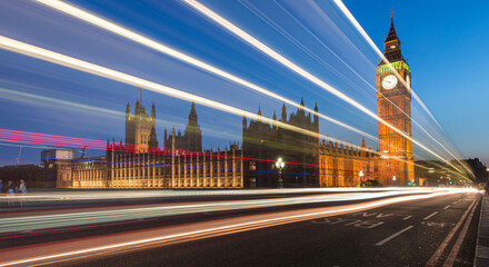 Cars drive past at twilight along the Westminster Bridge, Big Ben and the Houses of Parliament in London, England.