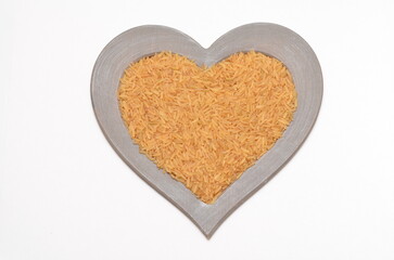 chinese bronze rice in a heart shaped frame on white background