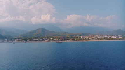 Panorama view of the blue sea. Beautiful clouds. Mountains in the background. Seascape. Photography