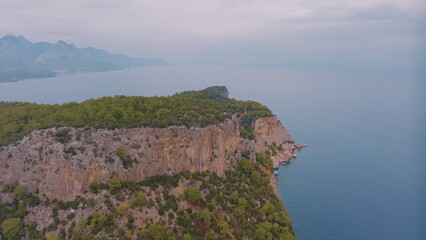 Fototapeta na wymiar Natural landscape. Aerial drone view of a beach in a blue bay. Rocky coast. Green trees on the rocks. 