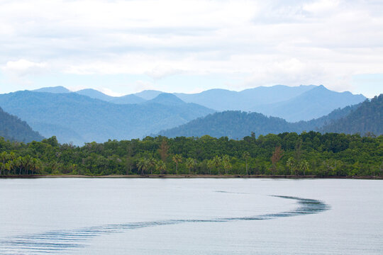 Jungle covered shoreline and hills along the shore of Morobe Bay; Morobe Province, Papua New Guinea