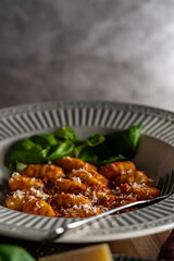 Gnocchi pasta with marinara sauce, garnished with fresh basil and parmesan cheese
.