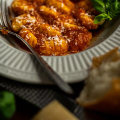 Gnocchi pasta with marinara sauce, garnished with fresh basil and parmesan cheese
.