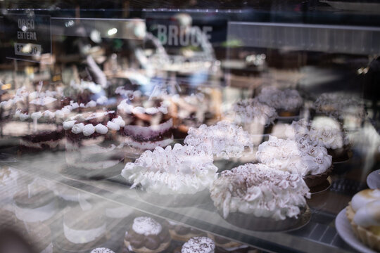 Doces em vitrine de confeitaria com reflexo.