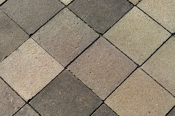 Cement tiles laid in diamond shapes, with a rough texture.