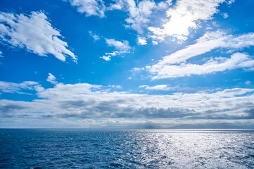View from the Iceland ferry Norrona when approaching the Faroe Islands over blue ocean water and clouds in the sky; Faroe Islands, Denmark