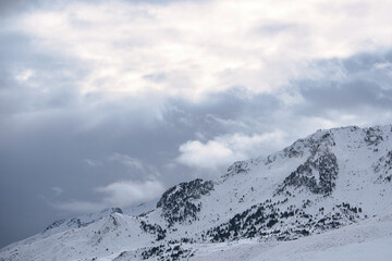 Fototapeta na wymiar Gran montaña nevada en un día nublado. Montaña rocosa y muy nevada