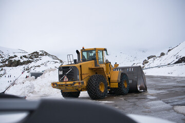 Quitanieves con cadenas amontonando nieve de la carretera. Máquina excavadora quitando nieve