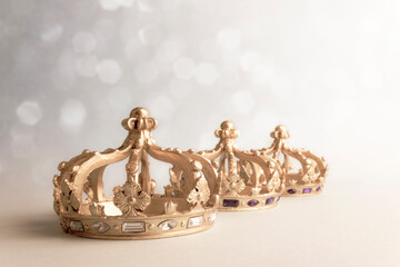 Happy Three King's Day. Three golden color crowns on light background. Concept for Reyes Magos, Three Wise Men or Happy Epiphany day.