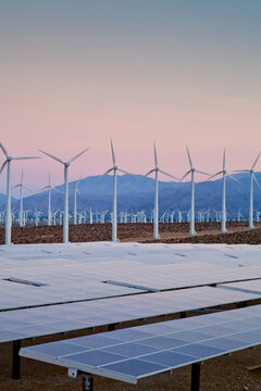 Environmentally friendly wind and solar energy collection in the desert at dusk.