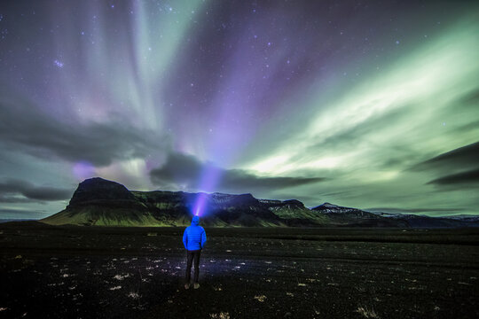 A man walks toward a distant mountain rage in a remote region of Iceland.