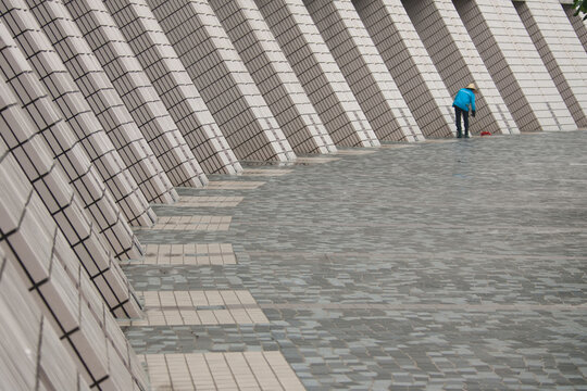 A woman sweeps along a Hong Kong building's courtyard.