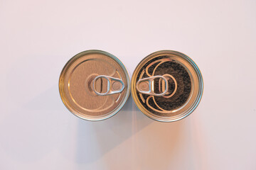 Aluminum can lids facing each other on a white background.