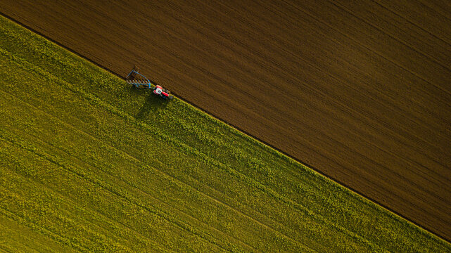 Drone photo of tractor ploughing field, Great Wilbraham; Cambridgeshire, England, United Kingdom - Powered by Adobe