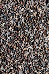 Texture background of small stones close-up, crushed stone, pebbles. Vertical orientation.