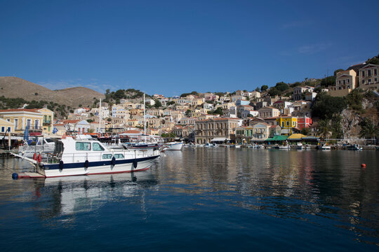 Cabin Cruisers and sailboats moored in the marina at Gialos Harbor, Symi (Simi) Island; Dodecanese Island Group, Greece