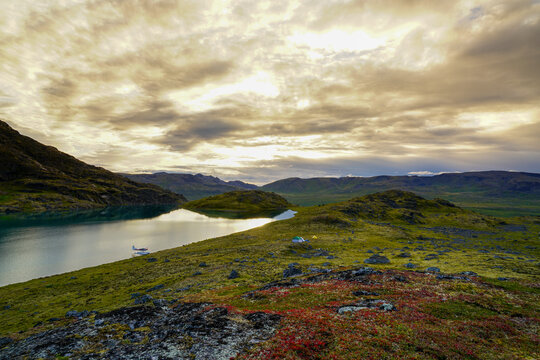Sheepback Lake in Talkeetna Mountains with a float plane moored at the shore at twilight; Alaska, United States of America
