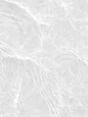 Defocus blurred transparent white colored clear calm water surface texture with splashes and bubbles. Trendy abstract nature background. Water waves in sunlight with copy space. White water shine