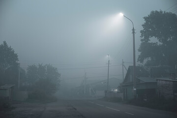 atmospheric photo in a smoky area of the city with private houses in the evening under the...