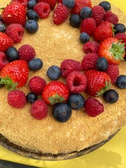 Close up of a birthday cake with berries on top