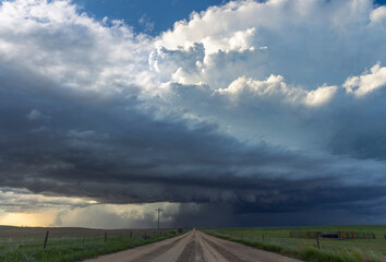 An enormous supercell thunderstorm crosses a dirt road in rural Nebraska; Imperial, Nebraska, United States of America