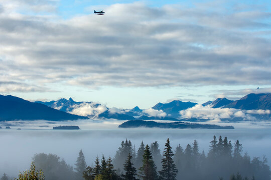 Foggy day over Kachemak Bay with a float plane overhead, Homer, Alaska, USA
