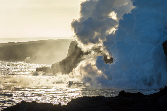 A tour boat approaches the lava ocean entry and a huge column of noxious gas on the Big Island of Hawaii; Hawaii, United States of America