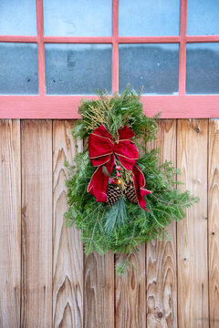 Close-up of homemade Holiday swag hanging on a barn door; Homer, Alaska, United States of America