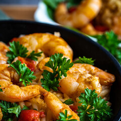 Shrimp scampi with pasta (orzo) garnished with parsley and grape tomatoes
