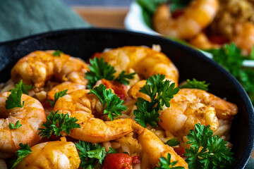 Shrimp scampi with pasta (orzo) garnished with parsley and grape tomatoes