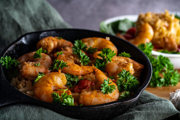 Shrimp scampi with pasta (orzo) garnished with parsley and grape tomatoes